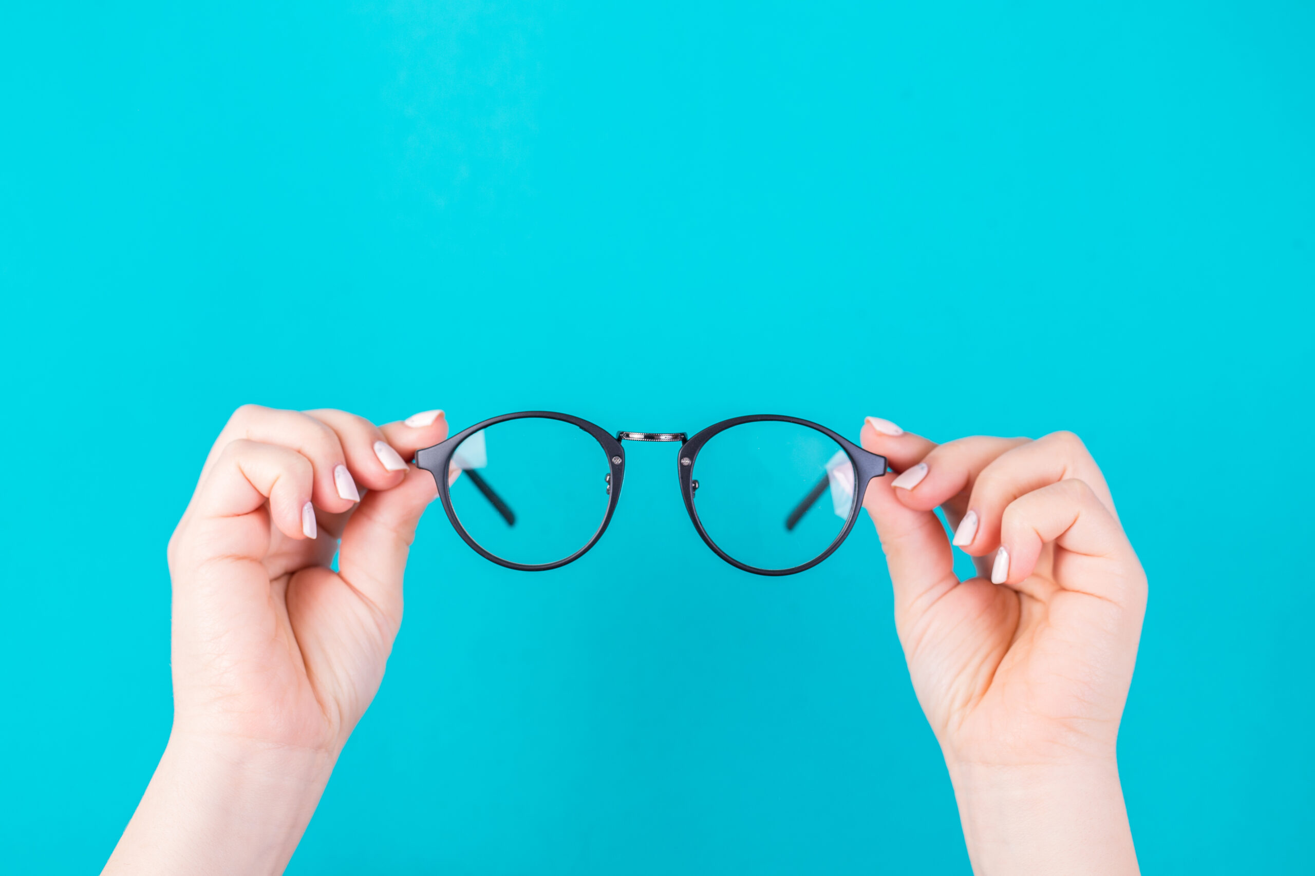 Hands holding glasses on a blue background
